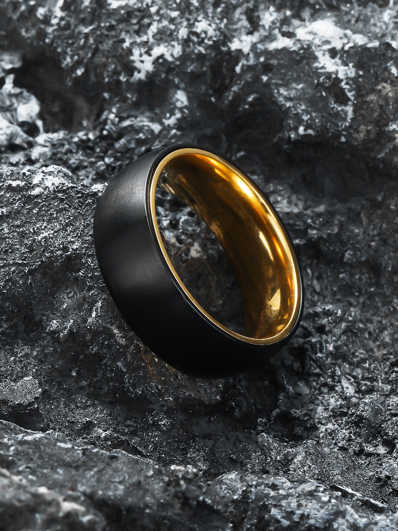 Side view of Black Gold Spinner Fidget Ring laid on natural rock - Calmfor stress relief jewelry