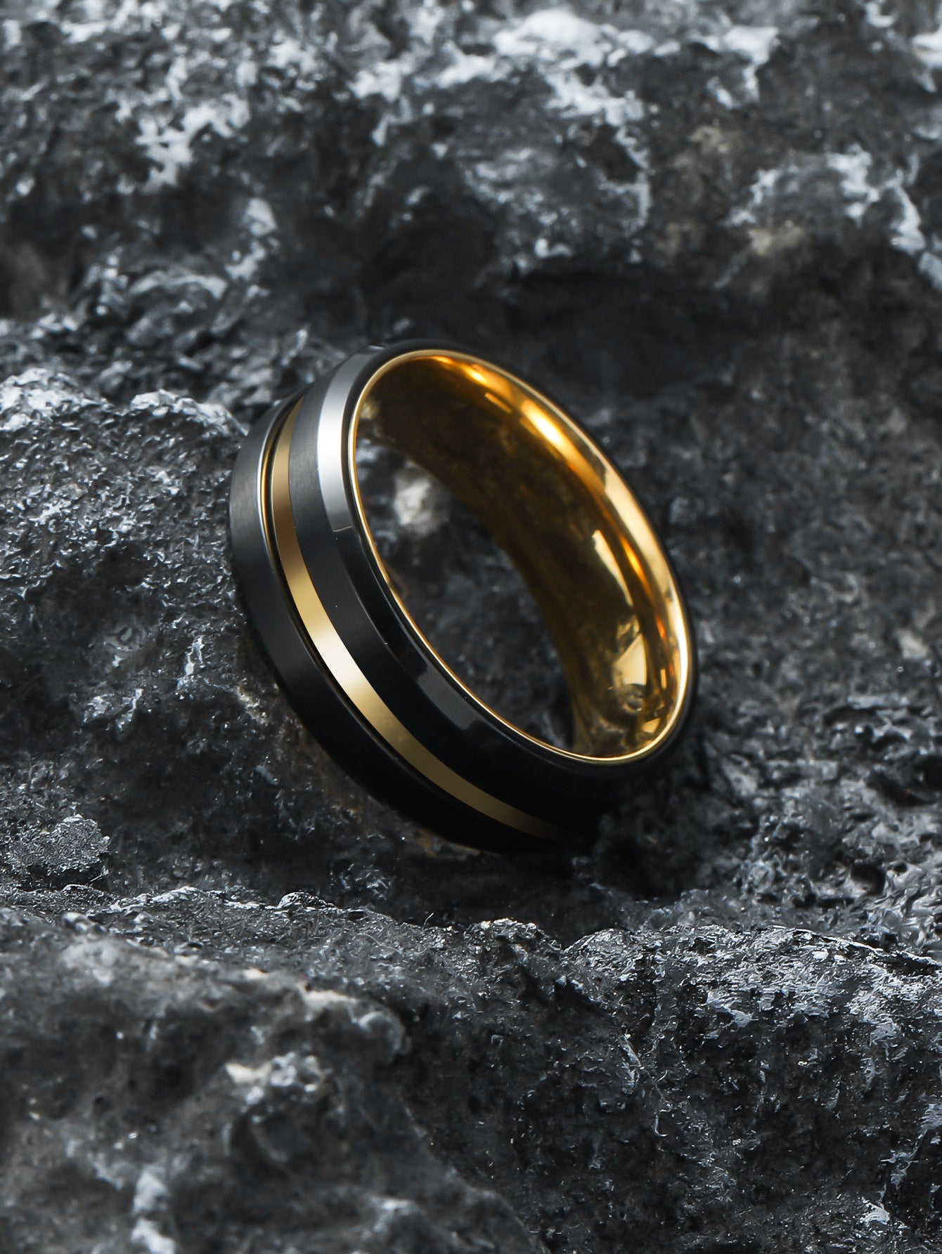 Black Gold Double Spinner Fidget Ring laid on natural rock surface – Calmfor stress relief jewelry