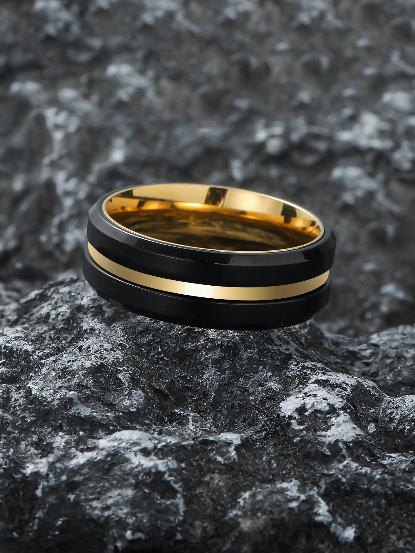 Flat-lay of Black Gold Double Spinner Fidget Ring placed on natural rock – Calmfor anti-anxiety jewelry